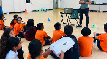 Students hold aficio22 gift boxes, examining the branding and packaging. Our founder, Kaveh, speaks to the students about the importance of branding and packaging in product development during our visit to A Step Beyond.